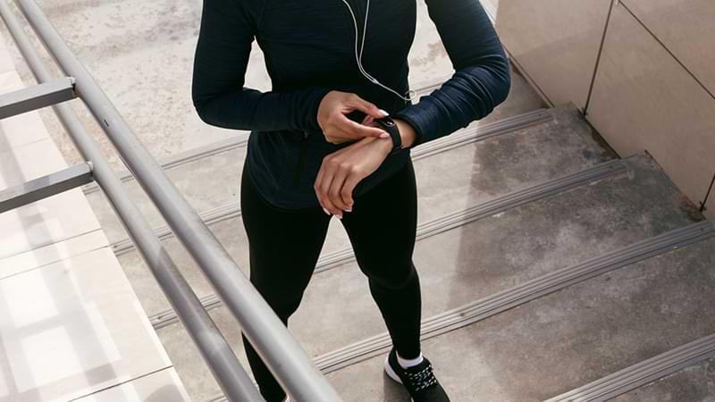 Woman checking heart rate using digital tracker on wrist